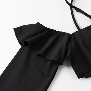 Dettaglio dei bordi con volant neri e della trama in maglia elasticizzata del top chic