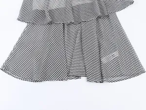Detail of tiered black and white polka dot chiffon fabric with layered ruffles