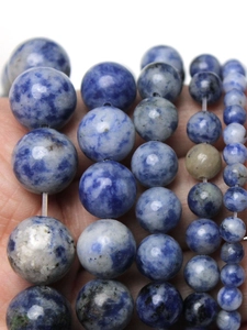 Close-up of various sized blue and white sodalite natural stone round beads for jewelry