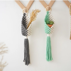 Detail of handmade macrame hanging baskets in grey-white and green-white cotton rope