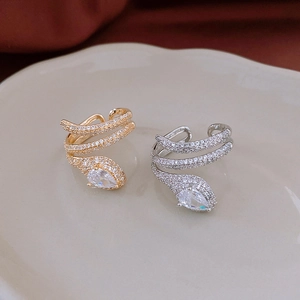 Close-up of gold and silver snake rings featuring sparkling zircon and teardrop stones