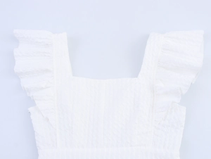 Detailed view of the square neckline and textured ruffle sleeves on a white dress
