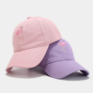 Pink and purple cotton baseball caps with embroidered flamingo designs on plain background