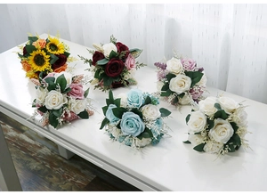Macro shot of artificial rose bouquets in various colors on a white minimalist table