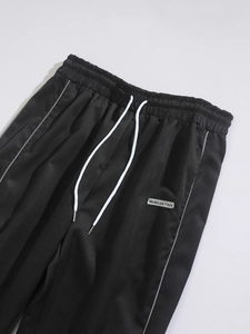 Detail of black jogger waist with white drawstrings and MuscleAttack logo patch