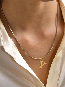 Close-up of minimalist gold initial Y necklace worn by a model on a silk shirt