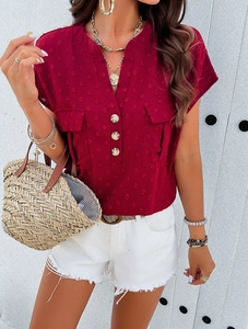Detail of red textured V-neck shirt featuring front buttons and two chest pockets