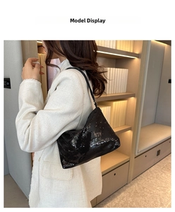 Détail du sac à bandoulière noir à paillettes porté par un mannequin pour soirée