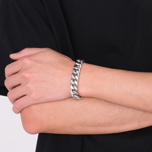 Vue détaillée d'un bracelet gourmette en acier inoxydable argenté porté au poignet