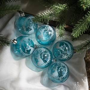 Blue clear Christmas ball with silver reindeer silhouette on white silk and pine