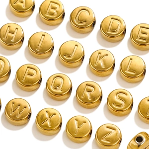 Detailed macro view of gold stainless steel alphabet beads with hole for DIY jewelry