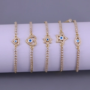 Gold evil eye charm bracelets with heart and star pendants set on a display stand