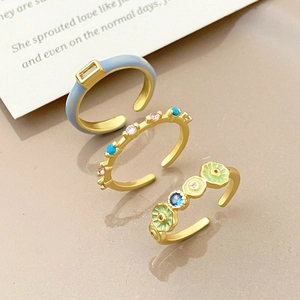 Detailed view of three-piece adjustable gold-plated ring set with blue zircon and enamel