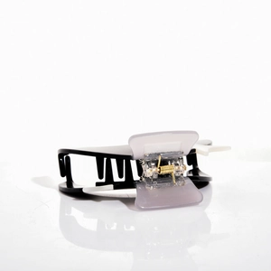 Detail of tricolor acetate hair claw clip with gold metal spring and smooth teeth