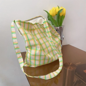 Close-up of green and orange plaid cotton canvas bag with simple wish brand label