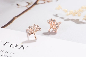 Detail of rose gold tree of life stud earrings with sparkling white cubic zirconia