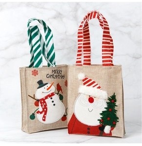 Detail of burlap Christmas gift bags featuring embroidered Santa and Snowman patterns