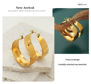 Close-up of chunky 18K gold plated U-shaped earrings with a polished mirror finish