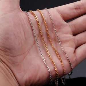 Detail of gold and silver stainless steel cross chains held in hand for texture