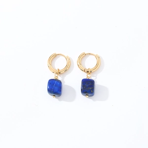 Close-up of geometric gold ring earrings with square blue lapis lazuli stone pendants