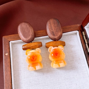 Close-up of wooden bear drop earrings with resin pendant in a jewelry display box
