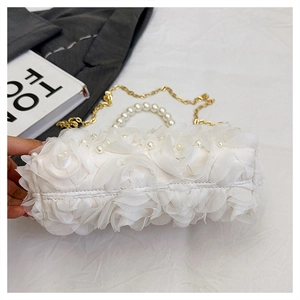Détail du sac en dentelle florale 3D blanche avec anse perle et chaîne dorée