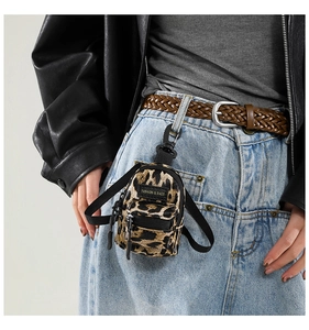 Close-up of leopard print mini bag accessory with dual zippers and carabiner clip