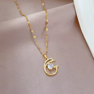 Macro shot of gold dolphin necklace with sparkling cubic zirconia on purple fabric