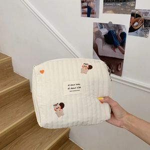 Close-up of quilted cotton baby stroller bag featuring cute bear and heart embroidery