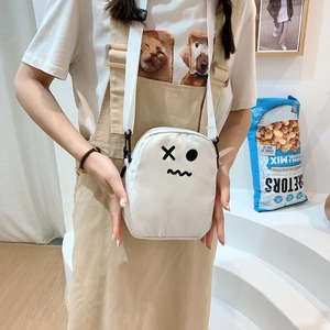 Gros plan d'un sac bandoulière blanc en toile avec motif dessin animé sur modèle