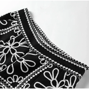 Detailed close-up of the waistband stitching and black and white floral print on the shorts