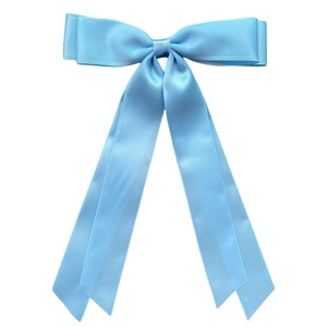 Detail of a sky blue satin ribbon bow hair clip with elegant long streamers on white background