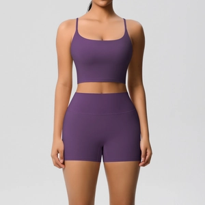 Detail of purple yoga set featuring thin strap crop top and high-waisted fitness shorts