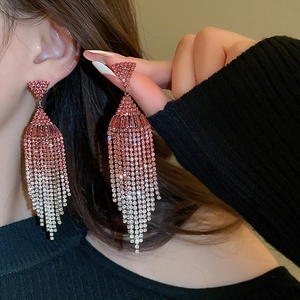 Detailed view of pink gradient tassel earrings with crystal rhinestones on a female model