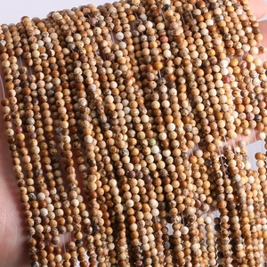 Close-up of 2mm-3mm natural stone beads in brown and beige for jewelry making