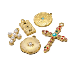 Assorted gold plated stainless steel pendants with pearls and rhinestones on white back