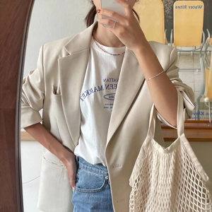 Chic beige oversized blazer and letter print T-shirt styled with a pearl necklace