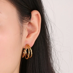 French vintage style geometric triple-layered gold C-shaped hoop earrings on model