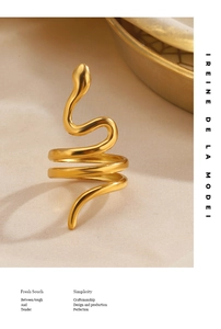 Gros plan détaillé d'une bague serpent plaquée or minimaliste sur un tissu texturé
