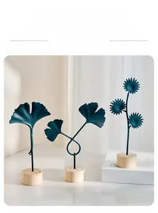 Detail of teal metal ginkgo leaves ornaments with cylindrical wooden bases