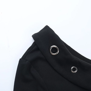 Nahaufnahme der Metallösen und Strickstruktur am schwarzen One-Shoulder Langarmshirt