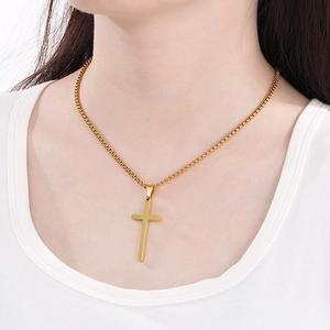 Polished gold stainless steel cross necklace on a model with a minimalist box chain