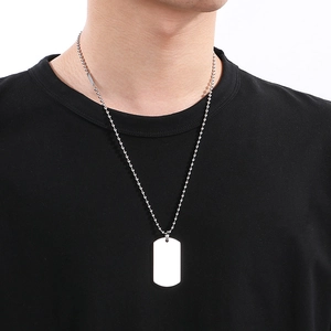 Close-up of a silver rectangular military dog tag pendant on a beaded chain for men