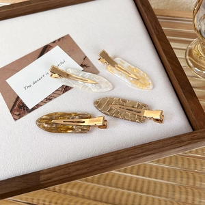 Detailed set of four tortoiseshell acetate hair clips with golden metal duckbill clips