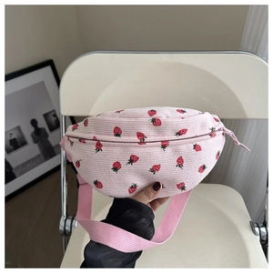 Detailed close-up of pink corduroy waist bag featuring red strawberry patterns