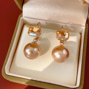 Elegant champagne pearl earrings with amber crystal drops in a luxury velvet jewelry box