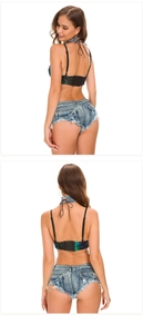 Dettaglio del top con paillettes verdi e shorts in denim sfrangiati con chiusura