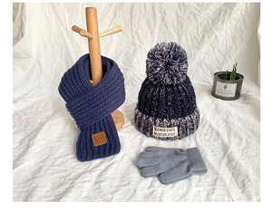 Detail of navy knit hat, scarf and gray gloves set with vintage patch for kids winter