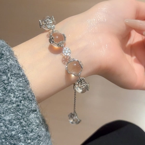 Detailed view of silver snowflake bracelet with translucent amber beads on wrist