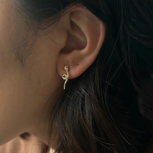 Detail view of a 18k gold S925 silver snake stud earring with sparkling crystals on ear